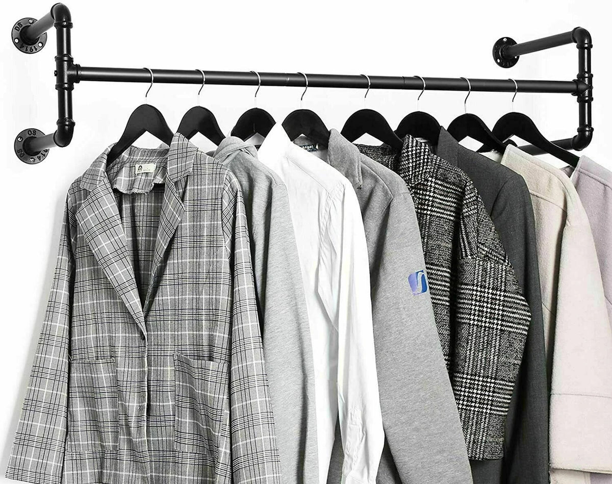 Black industrial pipe wall mounted clothes rack with a plaid blazer, shirts and coats hanging on black hangers