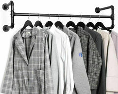 Black industrial pipe wall mounted clothes rack with a plaid blazer, shirts and coats hanging on black hangers
